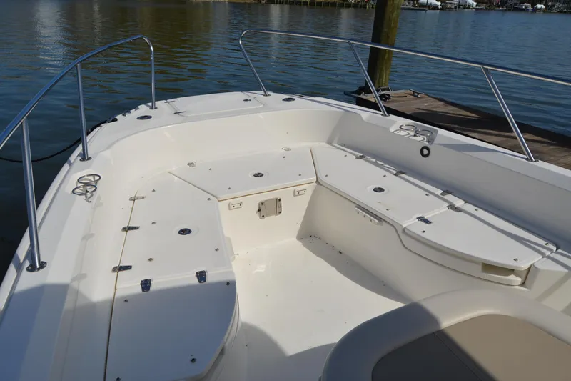 Slide: The Image of 2021 Boston Whaler 270 Dauntless boat interior with seating and storage, docked by the water. - 12