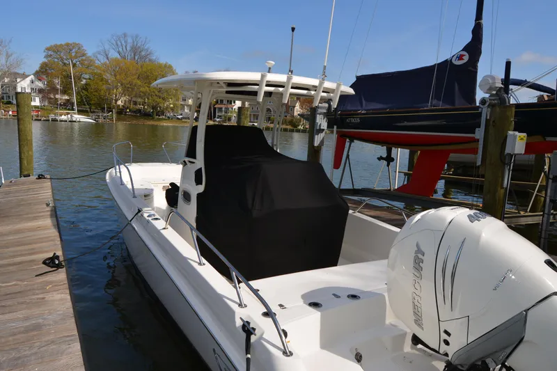 Slide: The Image of 2021 Boston Whaler 270 Dauntless docked, featuring Mercury outboard engine. - 2