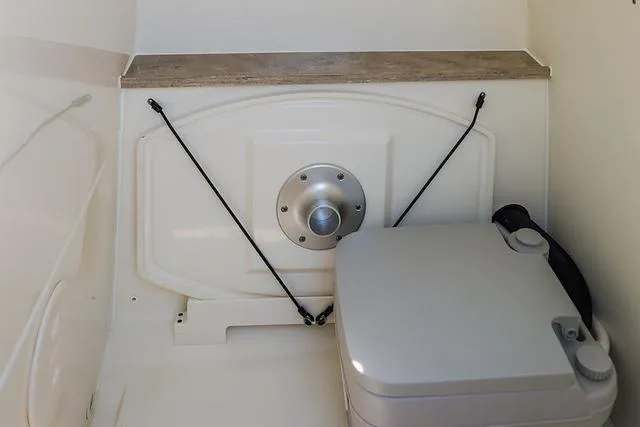 Slide: The Image of Manufacturer Provided Image: Interior of 2021 Boston Whaler 270 Dauntless boat with portable toilet. - 21