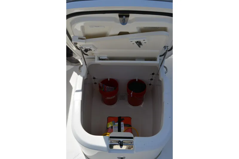 Slide: The Image of Open storage compartment on 2021 Boston Whaler 270 Dauntless boat with safety equipment. - 23