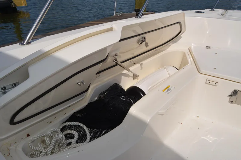 Slide: The Image of Open storage compartment on a 2021 Boston Whaler 270 Dauntless boat, showing ropes and gear. - 29