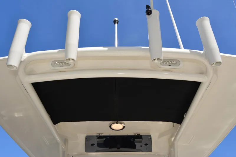 Slide: The Image of Boston Whaler 270 Dauntless 2021 boat roof with rod holders and lighting against blue sky. - 34