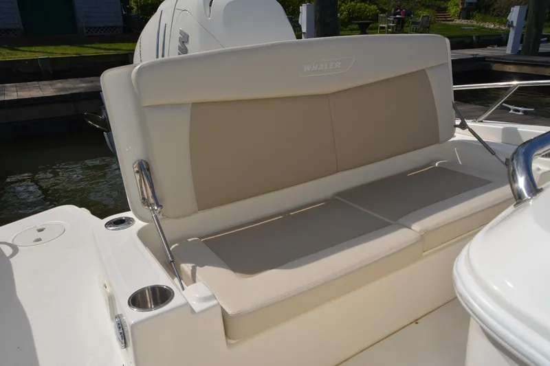 Slide: The Image of Boston Whaler 270 Dauntless 2021 boat seating area with beige cushions and cup holders. - 37