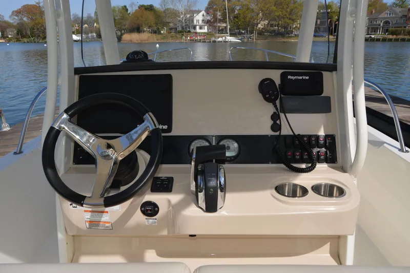 Slide: The Image of 2021 Boston Whaler 270 Dauntless helm with steering wheel and navigation controls. - 40
