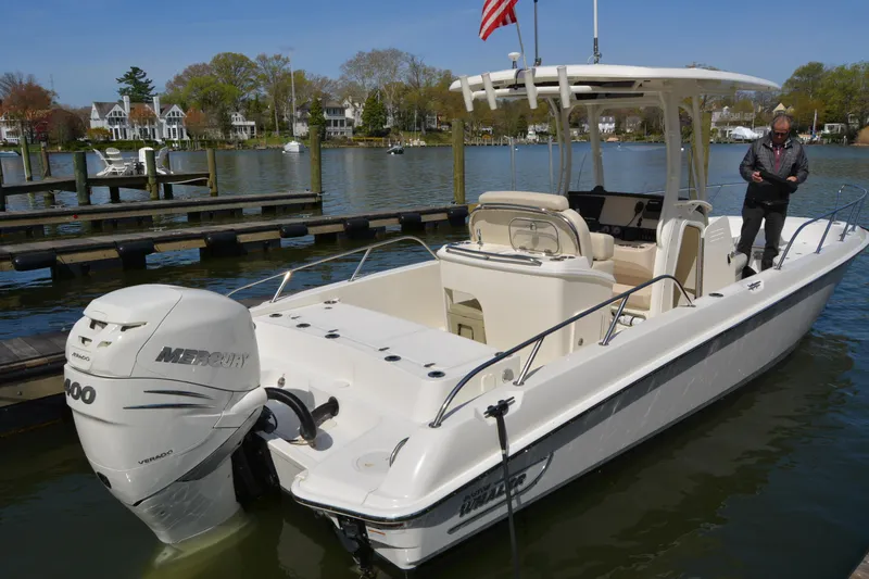 Slide: The Image of 2021 Boston Whaler 270 Dauntless boat docked with Mercury engine, calm waters in background. - 6