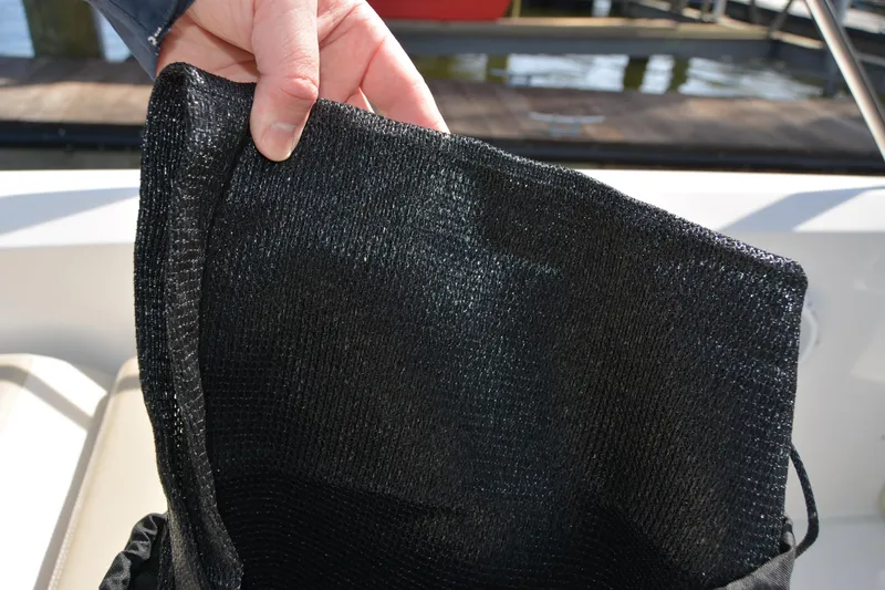 Slide: The Image of Hand holding black mesh bag on Boston Whaler 270 Dauntless boat, 2021 model. - 65