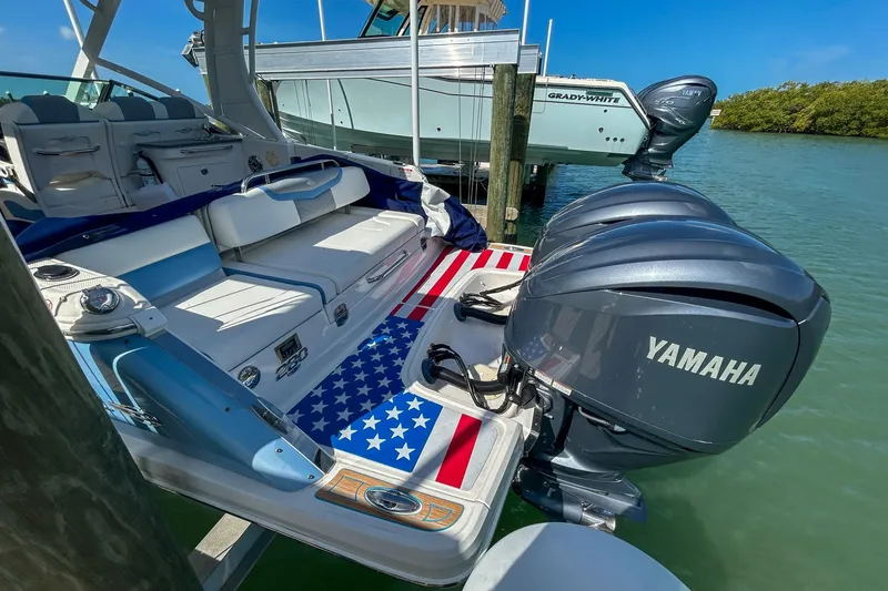 Slide: The Image of 2023 Chaparral 280 OSX boat with Yamaha engines, American flag design, docked in sunny marina. - 5