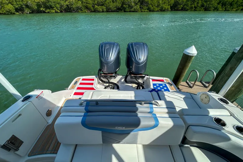 Slide: The Image of 2023 Chaparral 280 OSX boat with twin engines, docked by a serene waterway. - 6