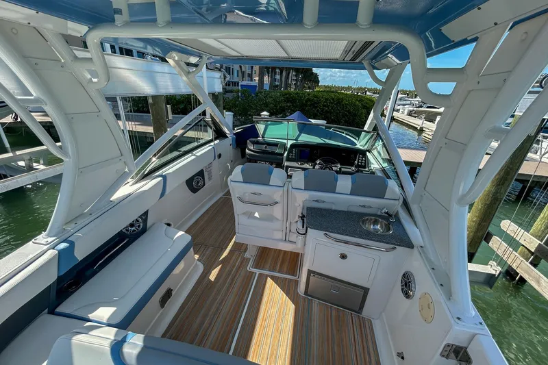 Slide: The Image of 2023 Chaparral 280 OSX boat interior with seating, helm, and kitchenette. - 7