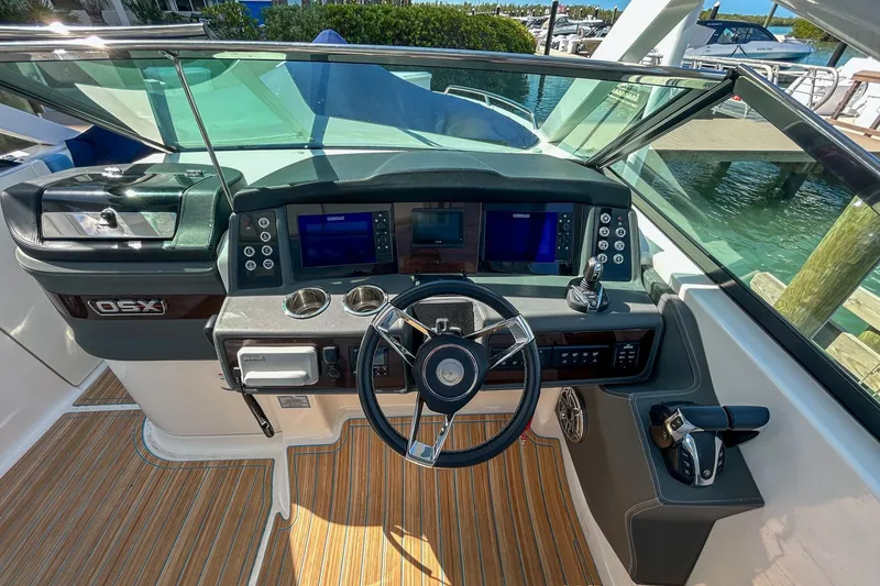 Slide: The Image of 2023 Chaparral 280 OSX boat dashboard with steering wheel and navigation screens. - 9