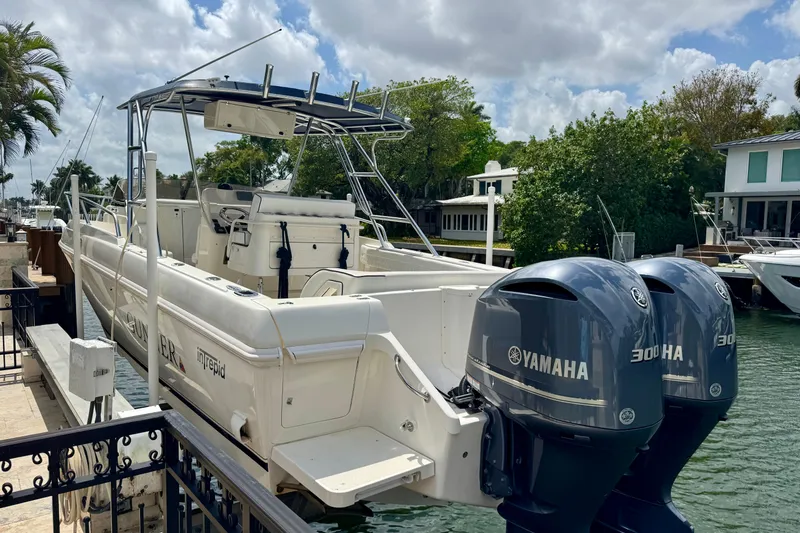 Slide: The Image of 2001 Intrepid 339 Walkaround boat with twin Yamaha 300 engines docked by waterfront homes. - 13