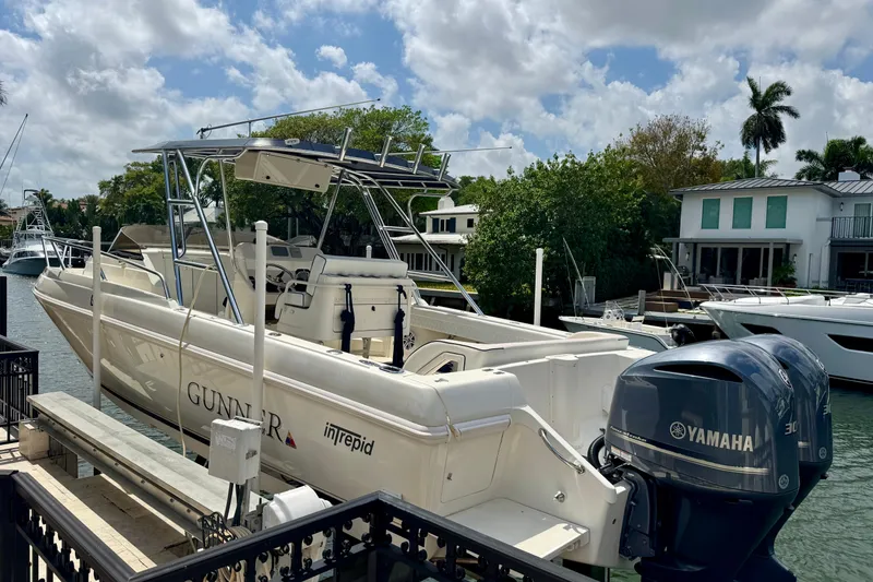 Slide: The Image of 2001 Intrepid 339 Walkaround boat docked with Yamaha engines, surrounded by waterfront homes. - 14