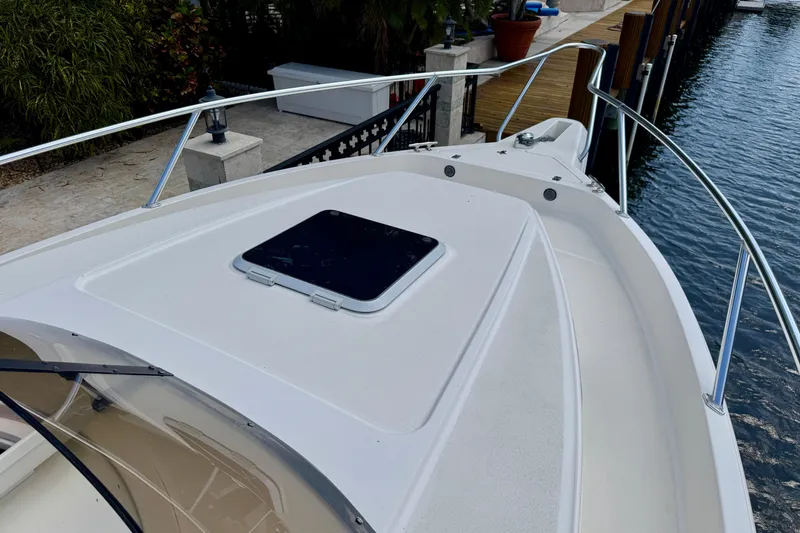 Slide: The Image of 2001 Intrepid 339 Walkaround boat deck with railing, docked by the water. - 24