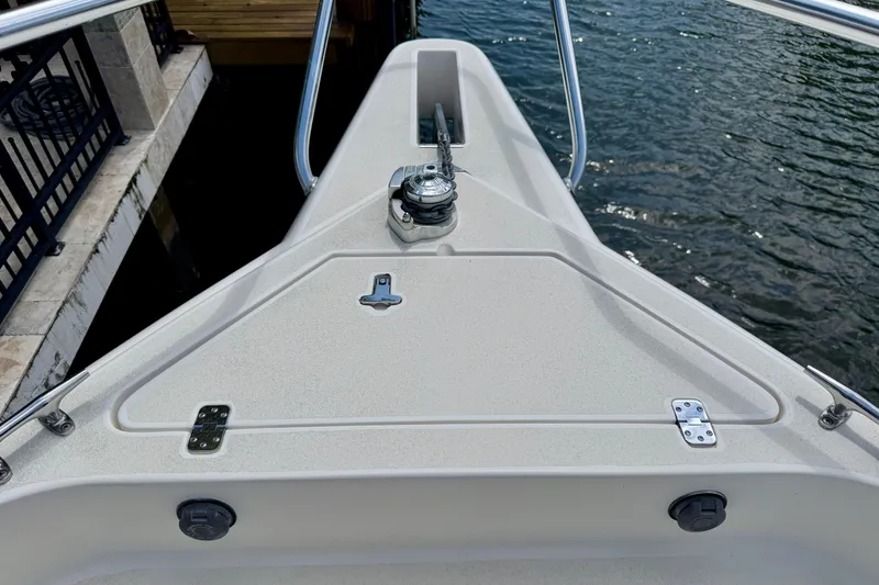 Slide: The Image of Bow of 2001 Intrepid 339 Walkaround boat with anchor and railing, docked by water. - 25