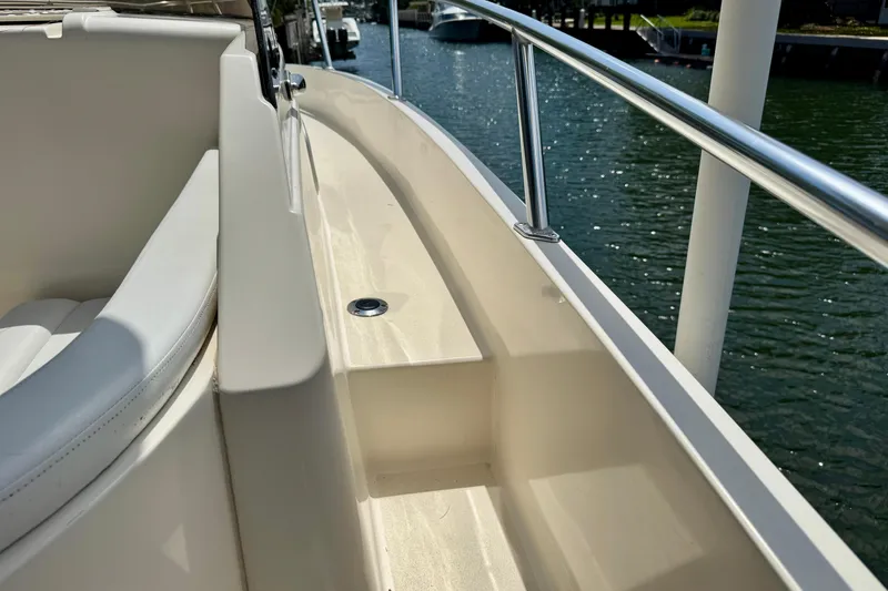 Slide: The Image of 2001 Intrepid 339 Walkaround boat deck with railing, docked by the water. - 27