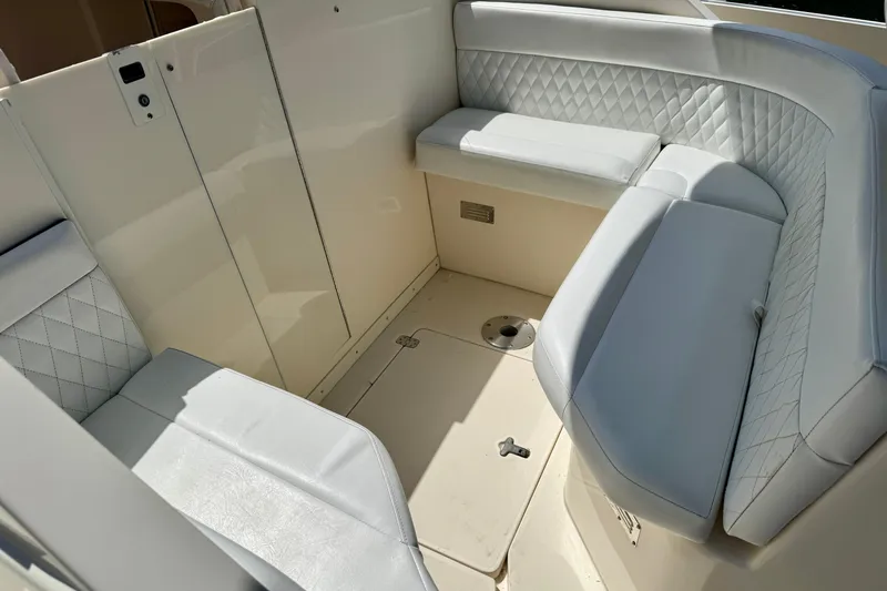 Slide: The Image of 2001 Intrepid 339 Walkaround boat interior with cushioned seating and quilted upholstery. - 29