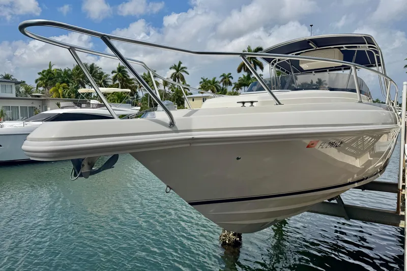 Slide: The Image of 2001 Intrepid 339 Walkaround boat docked in a marina, surrounded by palm trees. - 3