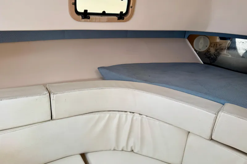 Slide: The Image of Interior cabin of a 2001 Intrepid 339 Walkaround boat with white seating and a small window. - 31