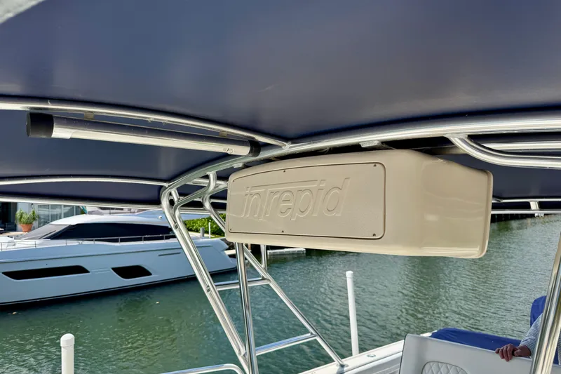 Slide: The Image of 2001 Intrepid 339 Walkaround boat interior with visible branding and marina background. - 41