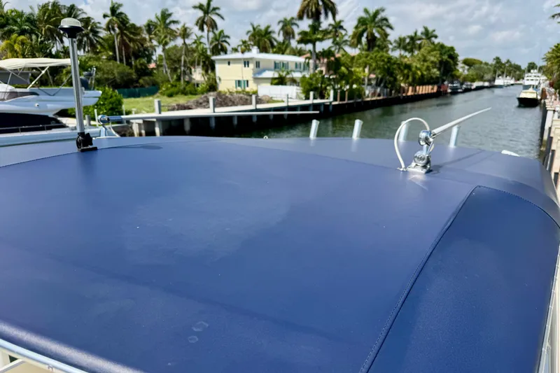Slide: The Image of 2001 Intrepid 339 Walkaround boat docked near palm trees and waterfront homes. - 42