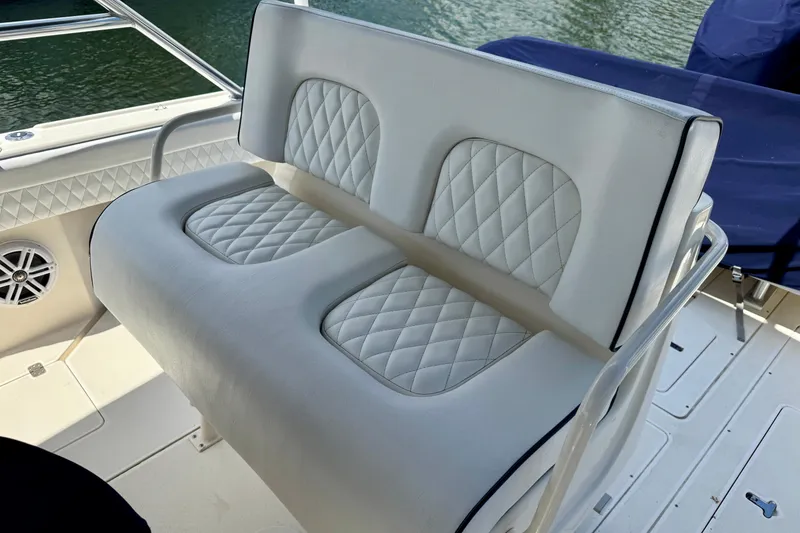 Slide: The Image of White cushioned seating on a 2001 Intrepid 339 Walkaround boat, featuring diamond-pattern upholstery. - 43