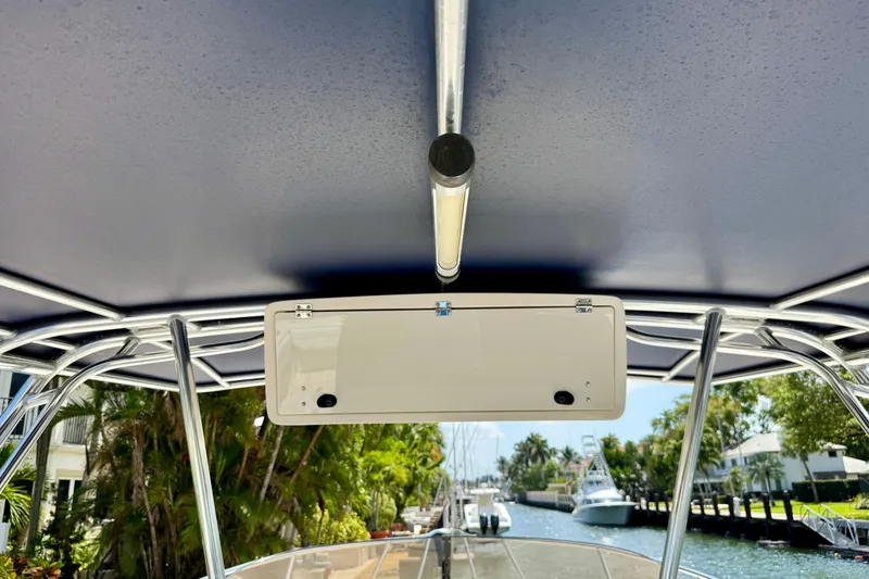 Slide: The Image of 2001 Intrepid 339 Walkaround boat canopy and console, docked near a scenic canal. - 44