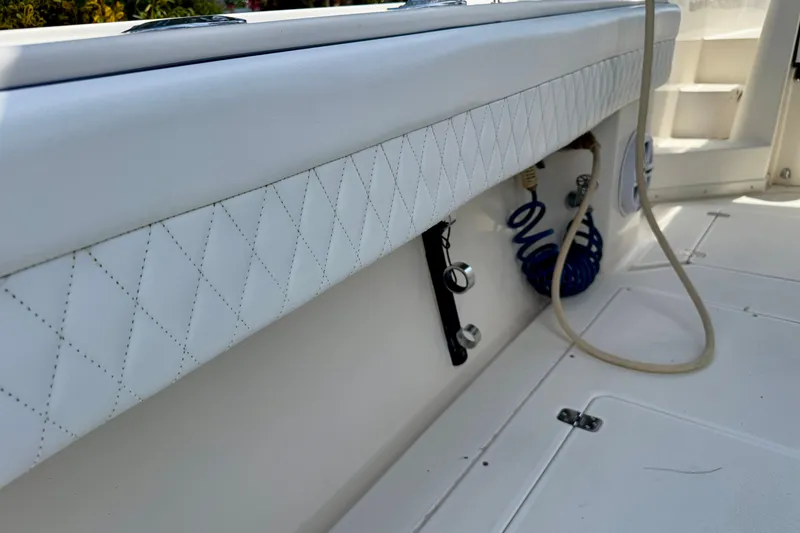 Slide: The Image of 2001 Intrepid 339 Walkaround boat interior with quilted upholstery and coiled hose. - 46