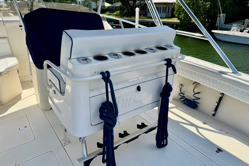 Slide: The Image of 2001 Intrepid 339 Walkaround boat interior with rod holders and blue ropes. - 47