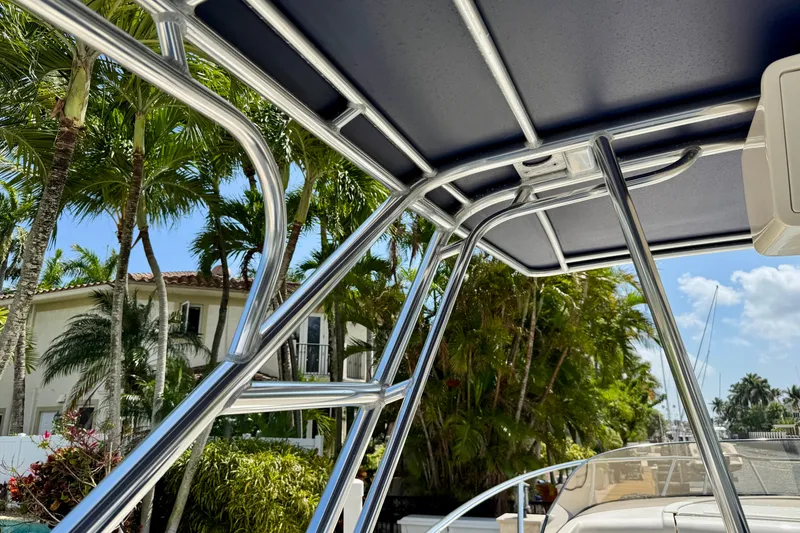 Slide: The Image of 2001 Intrepid 339 Walkaround boat with canopy, surrounded by tropical palm trees. - 50