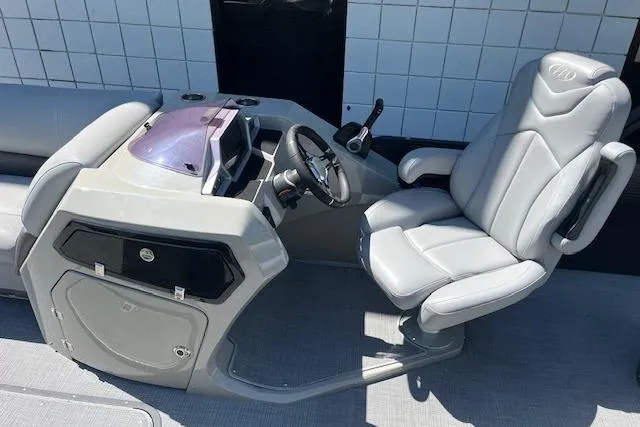 Slide: The Image of 2020 Manitou 25 OASIS SL VP boat cockpit with modern steering and comfortable seating. - 10