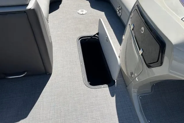 Slide: The Image of 2020 Manitou 25 OASIS SL VP boat interior with open storage compartment. - 11