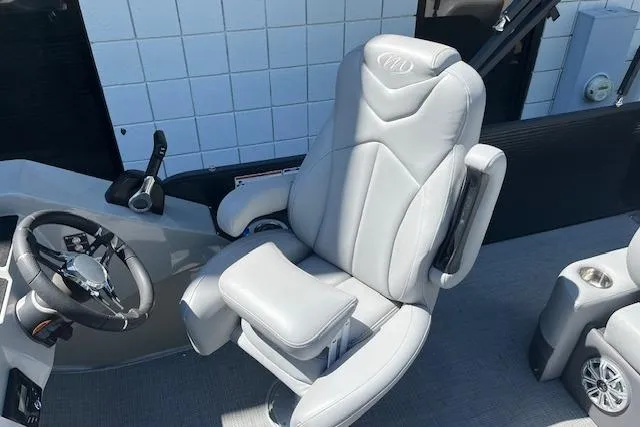 Slide: The Image of Captain's chair in 2020 Manitou 25 OASIS SL VP boat, featuring sleek design and modern controls. - 14