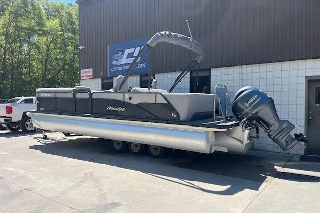 Slide: The Image of 2020 Manitou 25 OASIS SL VP pontoon boat with Yamaha outboard motor, parked outdoors. - 2