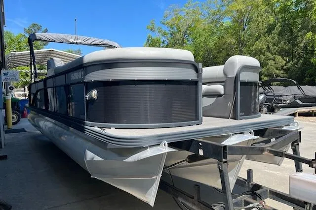 Slide: The Image of 2020 Manitou 25 OASIS SL VP pontoon boat on trailer, parked outdoors. - 5