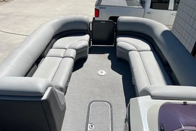 Slide: The Image of 2020 Manitou 25 OASIS SL VP pontoon boat with spacious gray seating and open deck. - 7