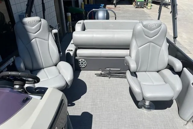 Slide: The Image of 2020 Manitou 25 OASIS SL VP boat interior with gray seating and steering wheel. - 9