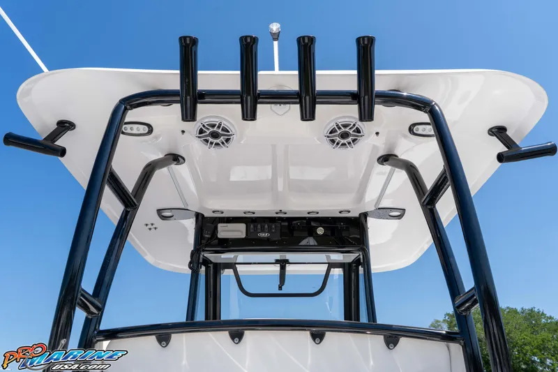 Slide: The Image of 2025 Sea Hunt Gamefish 28 boat's T-top with rod holders and speakers against blue sky. - 15