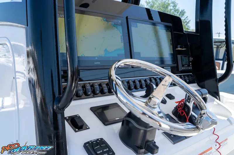 Slide: The Image of 2025 Sea Hunt Gamefish 28 helm with dual Garmin displays and sleek steering wheel. - 18