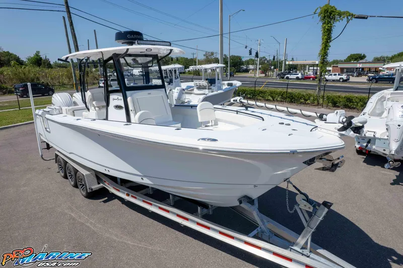 Slide: The Image of 2025 Sea Hunt Gamefish 28 Forward Seating boat on trailer in parking lot. - 28