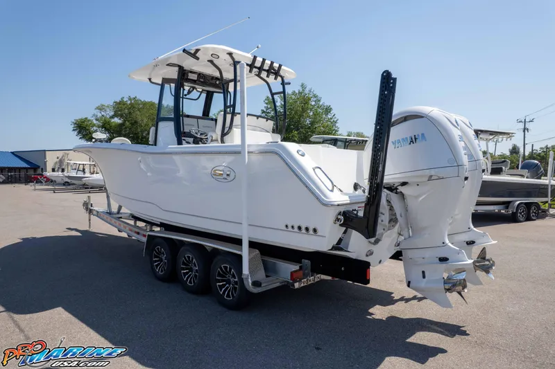 Slide: The Image of 2025 Sea Hunt Gamefish 28 Forward Seating boat on trailer, featuring dual Yamaha engines. - 38