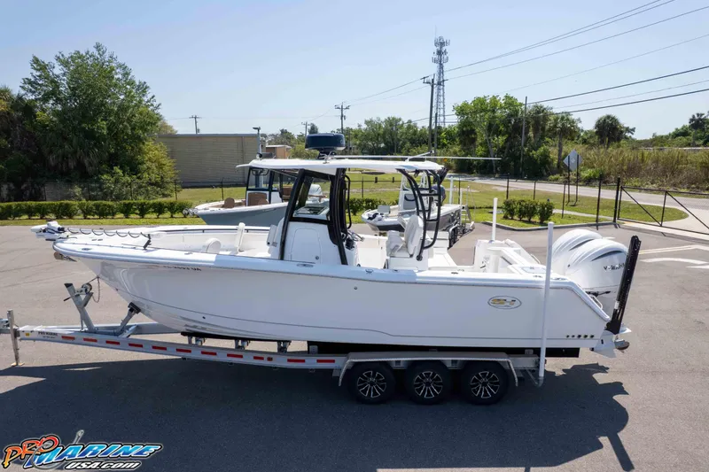 Slide: The Image of 2025 Sea Hunt Gamefish 28 Forward Seating boat on trailer in sunny outdoor setting. - 39