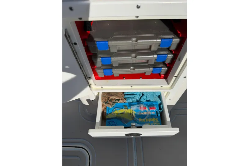 Slide: The Image of Storage compartments on a 2020 Tideline 235 Hybrid boat, featuring organized tackle boxes. - 15