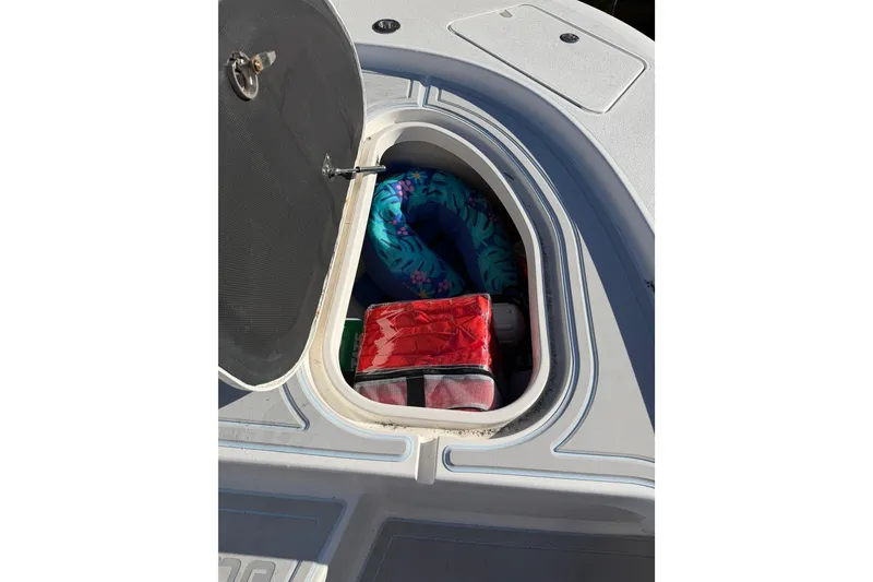 Slide: The Image of Open storage compartment on 2020 Tideline 235 Hybrid boat with colorful items inside. - 24