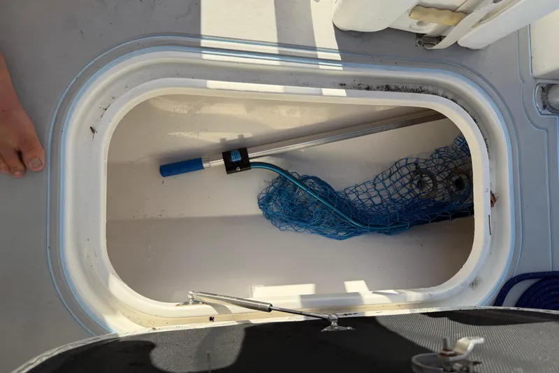 Slide: The Image of Open storage compartment on 2020 Tideline 235 Hybrid boat with fishing net and pole. - 27