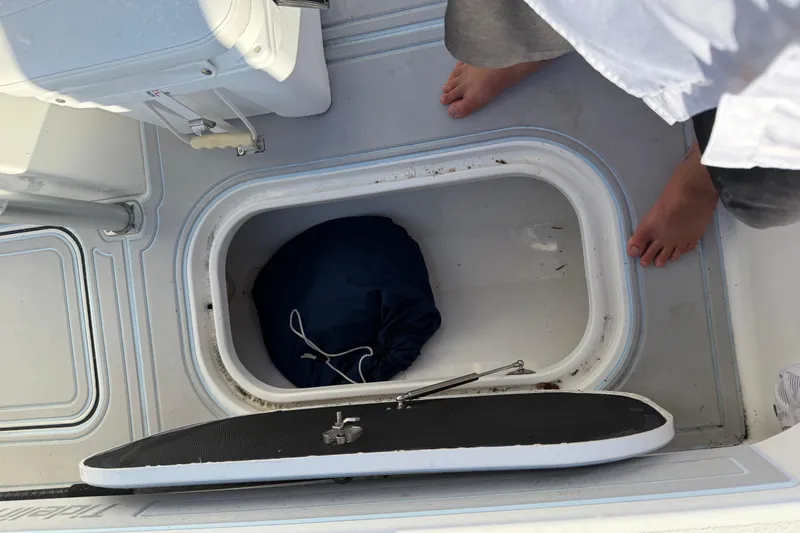 Slide: The Image of Open storage compartment on 2020 Tideline 235 Hybrid boat with blue bag inside. - 29