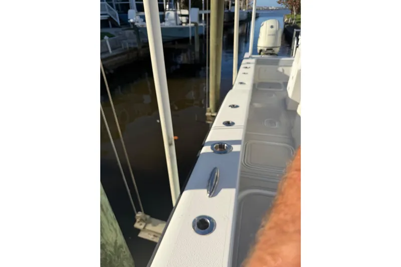 Slide: The Image of 2020 Tideline 235 Hybrid boat docked, showcasing deck and rod holders. - 30