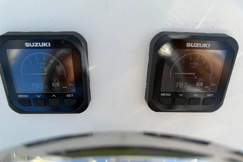Slide: The Image of Digital displays on a 2020 Tideline 235 Hybrid boat showing Suzuki engine hours. - 33