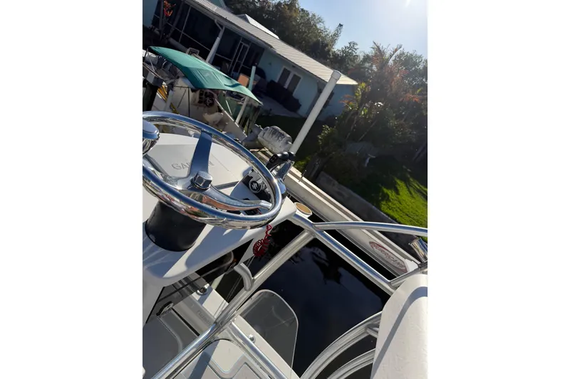 Slide: The Image of Steering wheel of a 2020 Tideline 235 Hybrid boat docked near a house. - 42