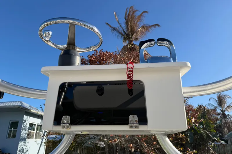 Slide: The Image of 2020 Tideline 235 Hybrid boat console with steering wheel and controls under clear blue sky. - 50