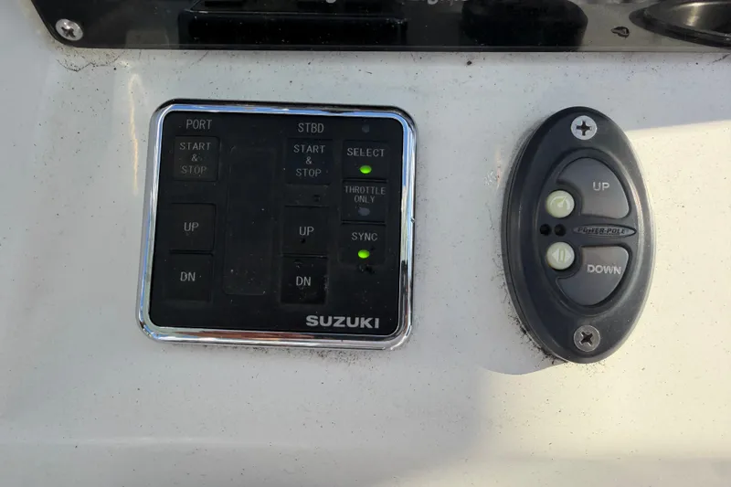 Slide: The Image of Control panel of a 2020 Tideline 235 Hybrid boat with Suzuki controls. - 51